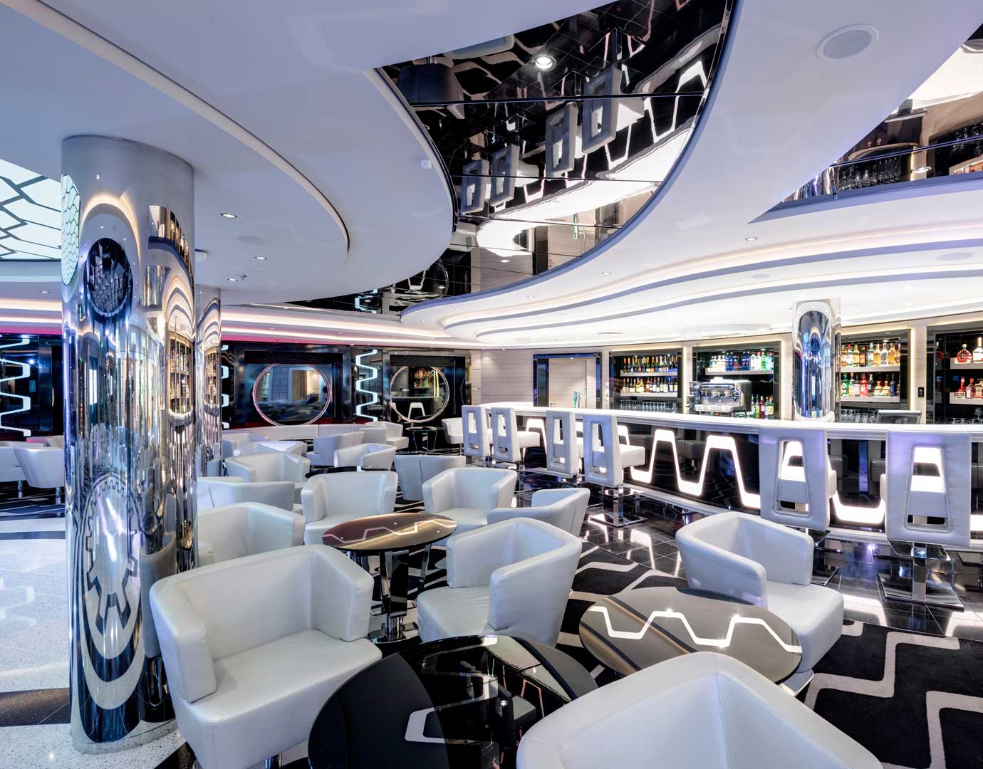 Modern cruise ship bar with sleek white seating and illuminated counters | MSC Cruises