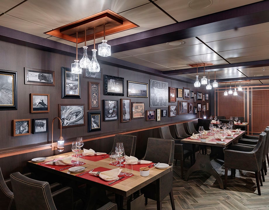 Elegant onboard restaurant with modern decor and framed art on the walls | MSC Cruises
