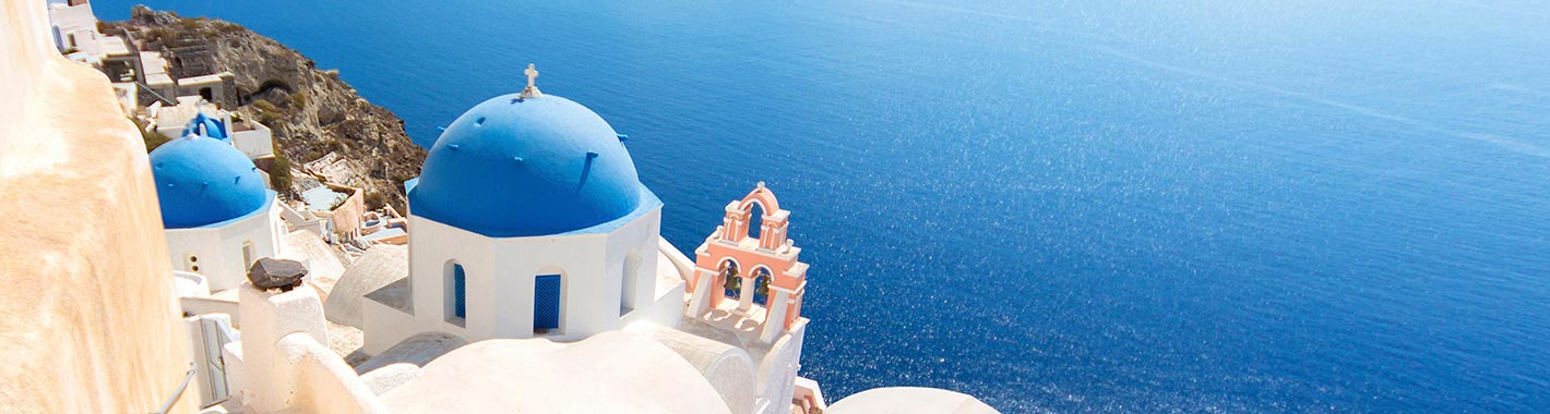 Santorini's iconic blue-domed churches overlooking the Aegean Sea | MSC Cruises