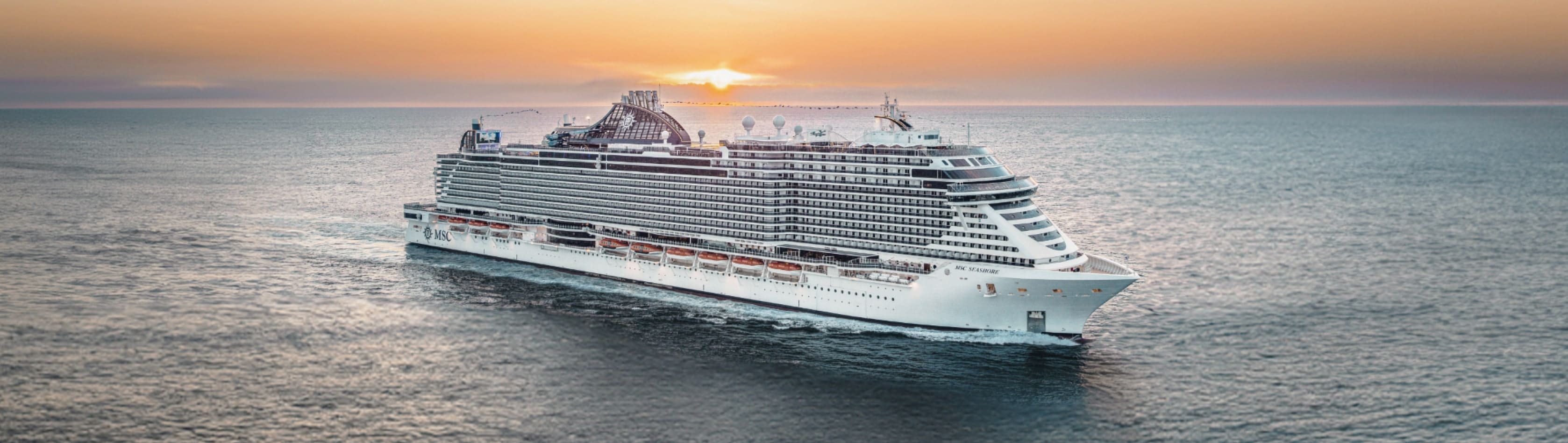 MSC Cruises cruise ship MSC Seashore sailing on the open sea with a setting sun in the background.