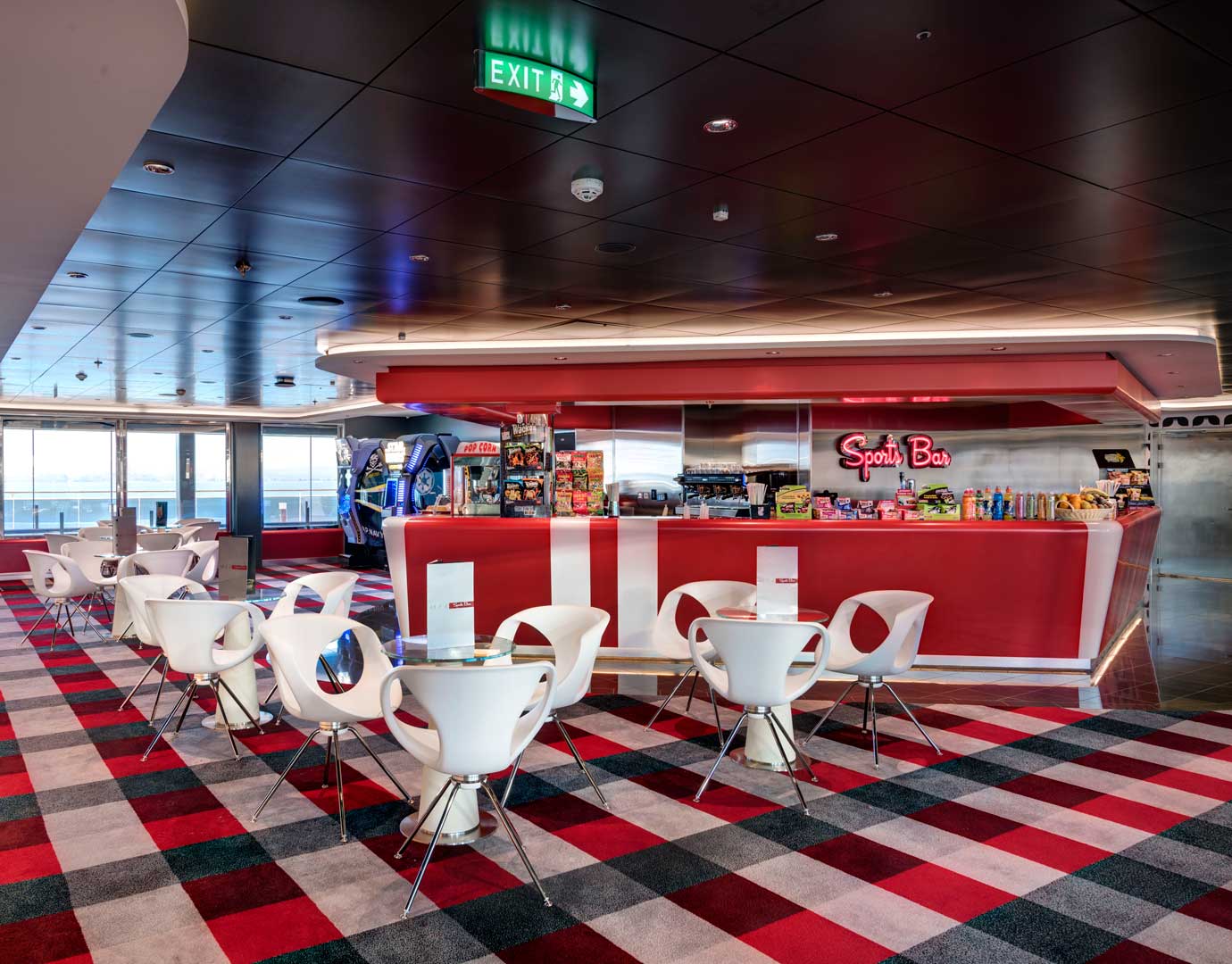 Modern sports bar with red decor, white chairs, and snack options onboard a cruise ship | MSC Cruises